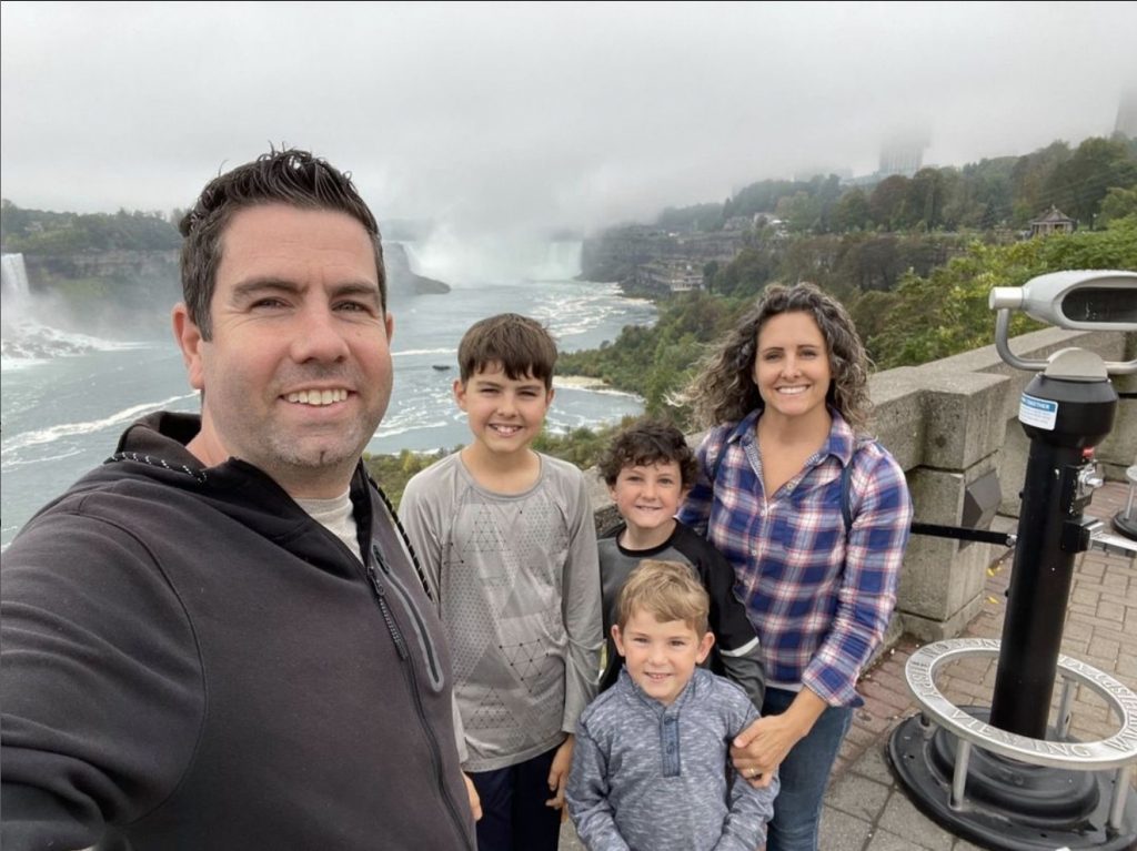 standing in front of Niagara Falls in Ontario, Canada for a family vacation picture