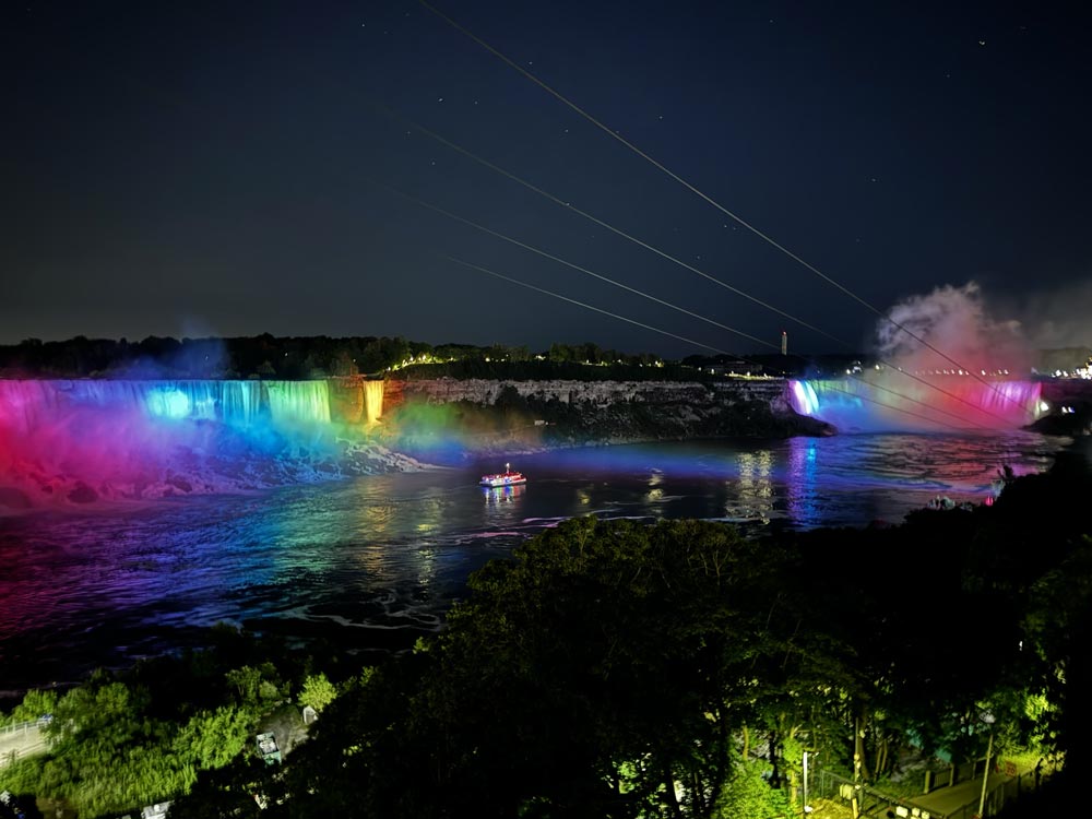 Niagara Falls lit up in rainbox colors at night