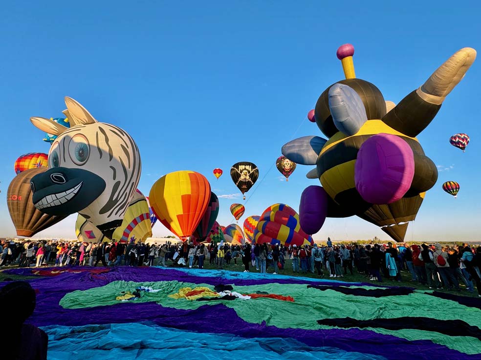 Colorful hot air balloons floating in the sky during the Albuquerque International Balloon Fiesta.